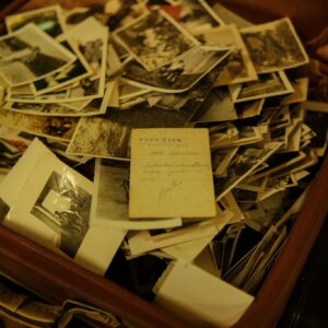 A collection of vintage photographs scattered inside an open suitcase, evoking nostalgia and memories.