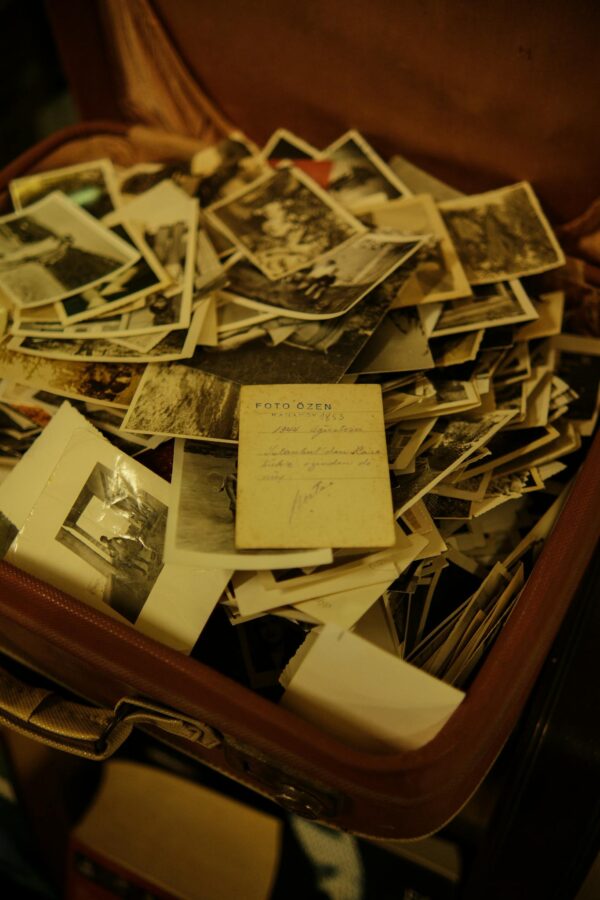 A collection of vintage photographs scattered inside an open suitcase, evoking nostalgia and memories.