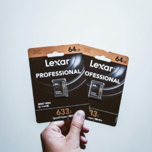 Close-up of a hand holding two Lexar Professional 64GB SD cards, ideal for high-speed storage solutions.