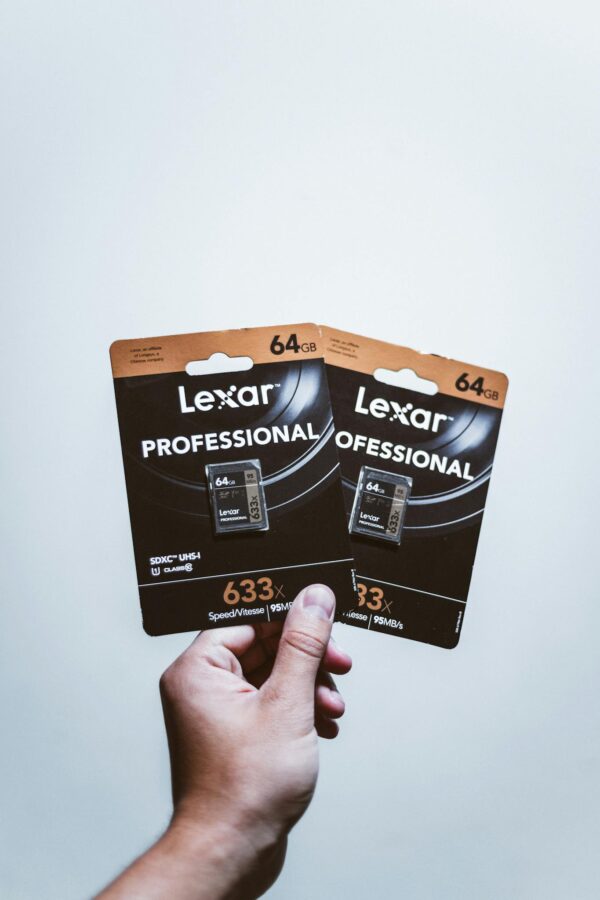 Close-up of a hand holding two Lexar Professional 64GB SD cards, ideal for high-speed storage solutions.