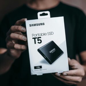 Close-up of a person holding a Samsung T5 Portable SSD box, emphasizing modern technology.