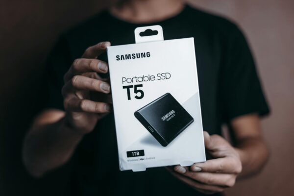 Close-up of a person holding a Samsung T5 Portable SSD box, emphasizing modern technology.